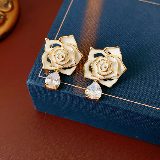 Gold-tone rose stud earrings with ivory and black enamel petals plus teardrop zircon dangles — Gilded Rose Teardrop Studs.