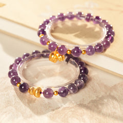 Natural amethyst beaded bangle with gold-tone accents and a lucky charm (Floral or Gourd) — Violet Fortune Amethyst Bangle.