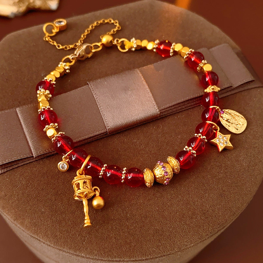 Aurora Red Prosperity Bracelet with red crystal beads and golden fortune charms—star, coin, and drum—on adjustable chain – Glazenya