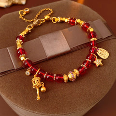 Aurora Red Prosperity Bracelet with red crystal beads and golden fortune charms—star, coin, and drum—on adjustable chain – Glazenya