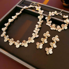 Golden Petal Elegance Set with necklace, bracelet, and earrings featuring golden floral petal details