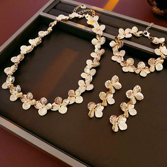 Golden Petal Elegance Set with necklace, bracelet, and earrings featuring golden floral petal details