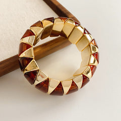 Gold-tone segmented bangle with marbled acrylic dome tiles — Gilded Capsule Resin Bangle.