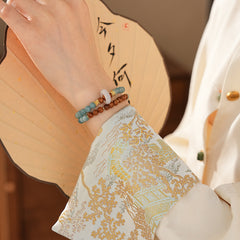A double-wrap bracelet of sea blue and brown chalcedony beads, embellished with white rings - Dual-Tone Chalcedony Double-Wrap Bracelet.