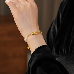Gold link and pearl chain bracelet with zircon accents on green velvet background – Celestial Pearl Chain Bracelet by Glazenya