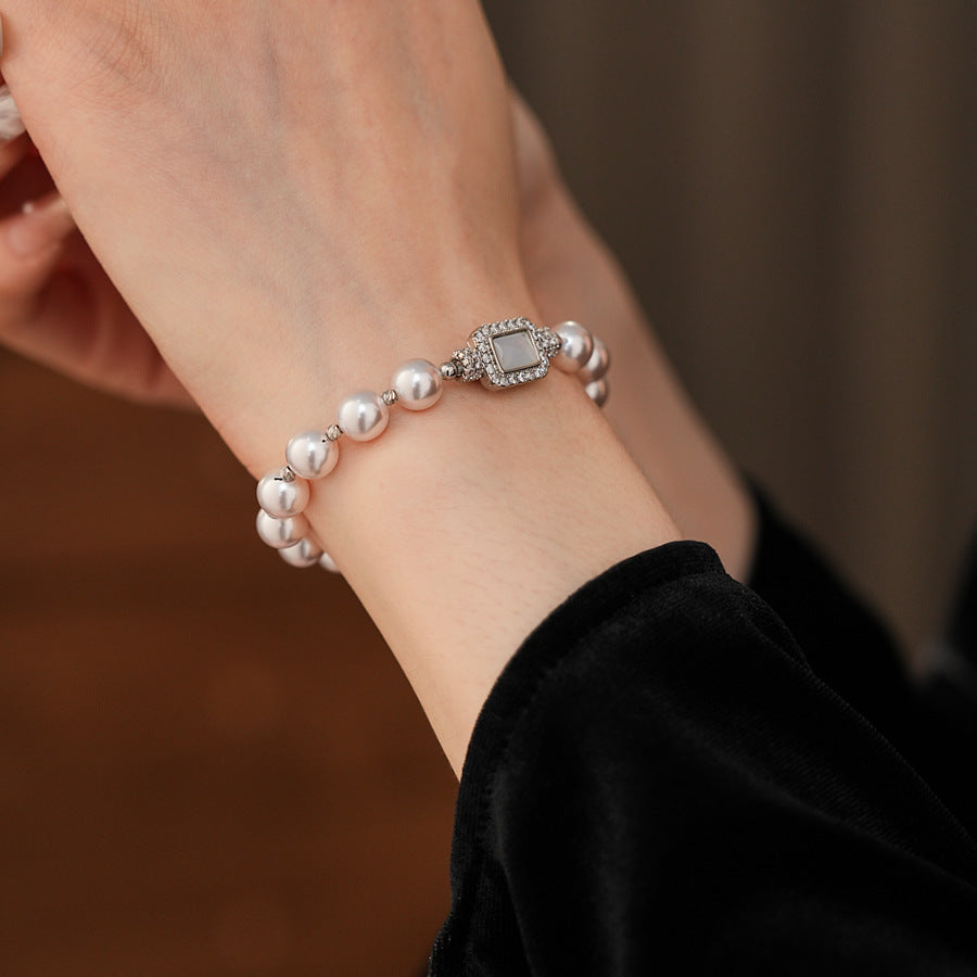 Deco Halo Pearl Bracelet featuring luminous pearls and a pavé-framed rectangular mother-of-pearl charm.