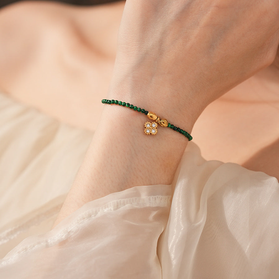 Two variant options of a malachite charm bracelet: beaded green strand with a crystal bloom charm, and a gold-tone chain with malachite accents and a heart pendant — Malachite Charm Bracelet (Variants).