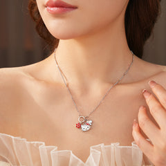 Silver-tone necklace with a cute cat face charm, red bow, red flower and clover accents; copper base with zircon details; 52 cm chain, 1.6 cm pendant, displayed on a black jewelry pad.