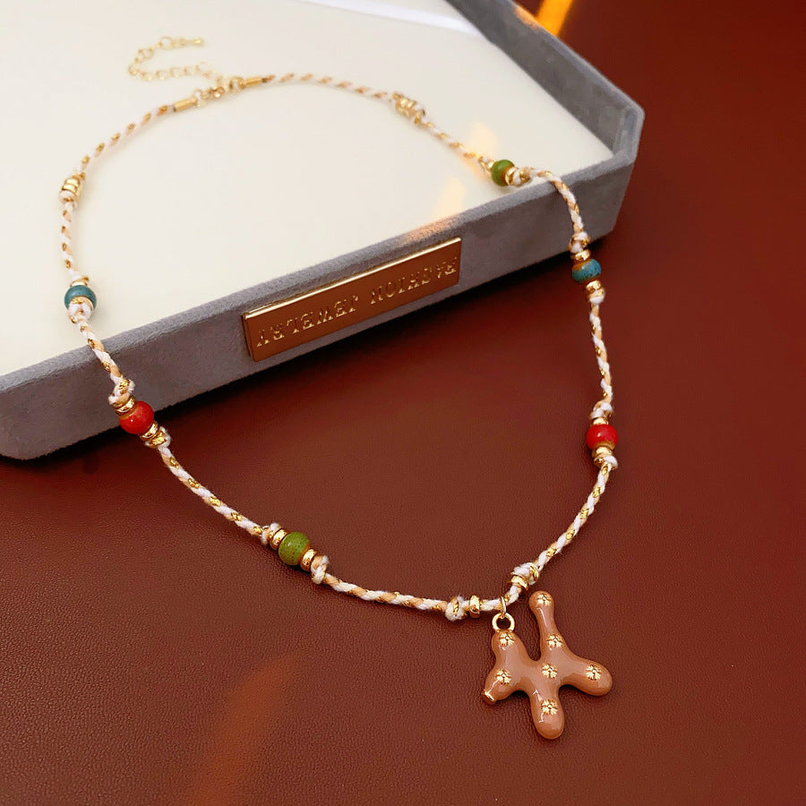 Boho ceramic charm rope necklace with multicolor beads and tan enamel pendant on cotton cord