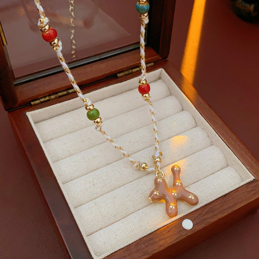 Boho ceramic charm rope necklace with multicolor beads and tan enamel pendant on cotton cord