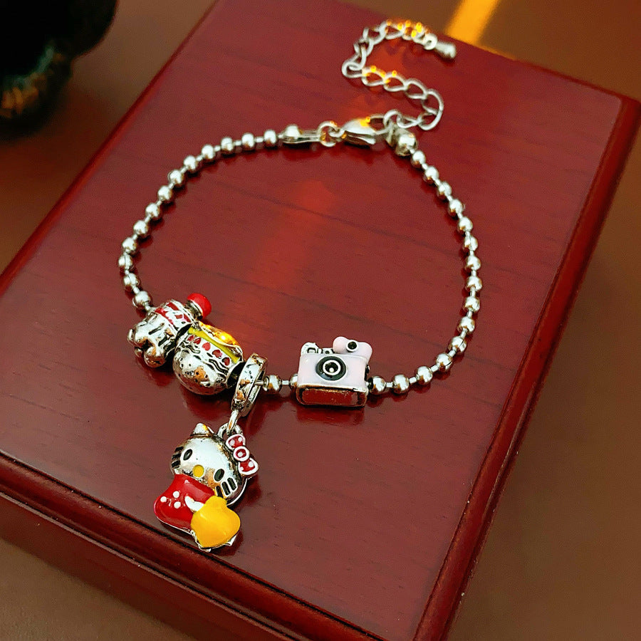 Kawaii Charm Story Bracelet with cartoon cat, burger, camera, and bell charms on silver-tone bead chain