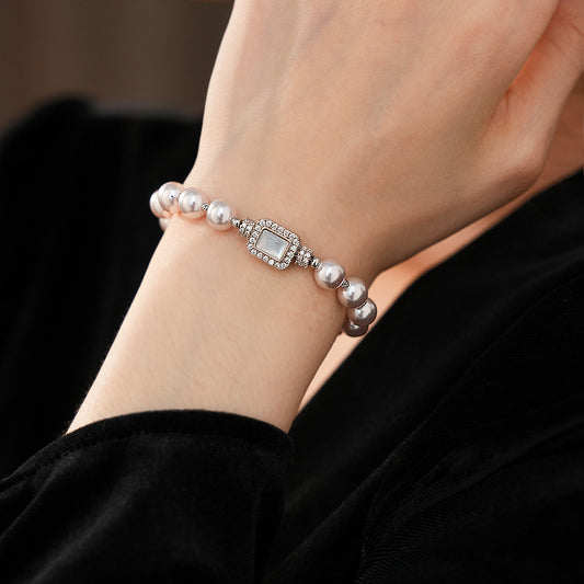 Deco Halo Pearl Bracelet featuring luminous pearls and a pavé-framed rectangular mother-of-pearl charm.