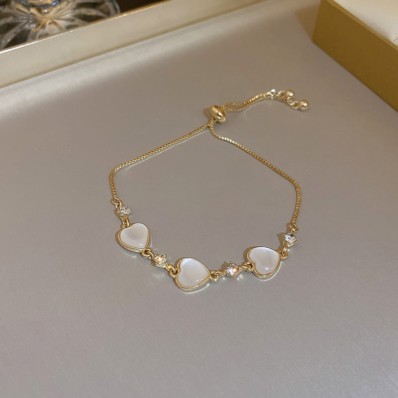 Gold-plated bracelet collection with pearls, cat’s eye stones, and floral motifs