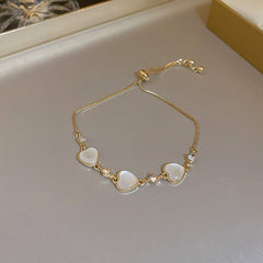 Gold-plated bracelet collection with pearls, cat’s eye stones, and floral motifs