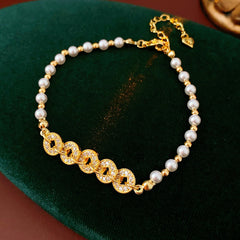 Gold link and pearl chain bracelet with zircon accents on green velvet background – Celestial Pearl Chain Bracelet by Glazenya