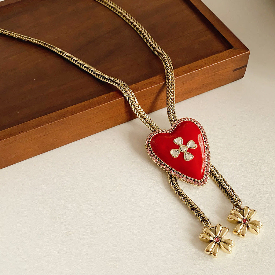 Lariat necklace with beaded-edge heart pendant and twin tassel blossoms on model — Regal Heart Tassel Lariat Necklace.