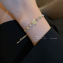 Gold-plated bracelet collection with pearls, cat’s eye stones, and floral motifs