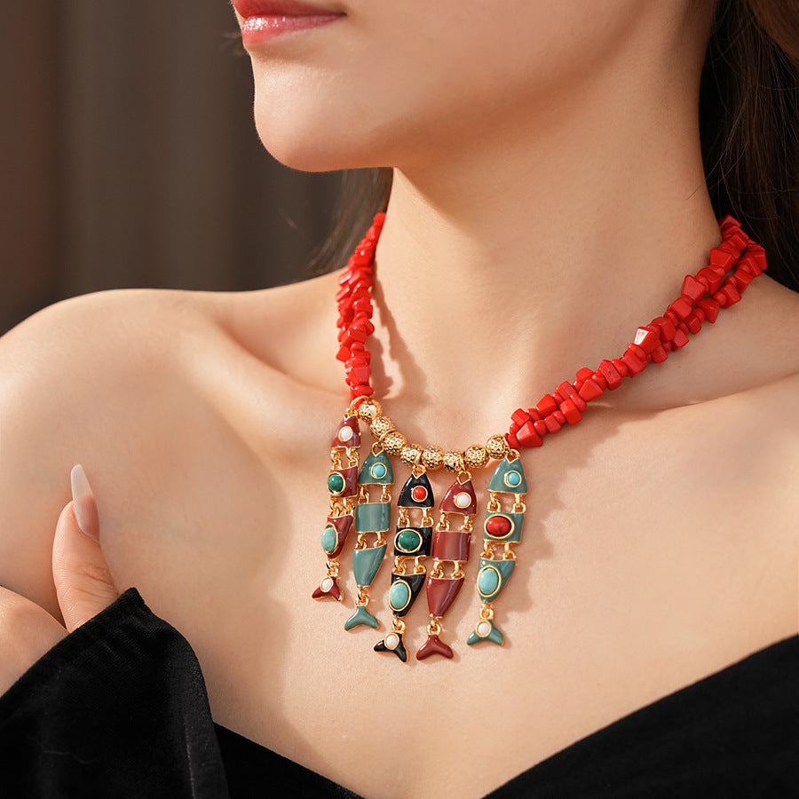 Statement necklace with articulated fishbone fringe, gold beads, and red or black chip strands — Kaleido Fishbone Fringe Necklace.