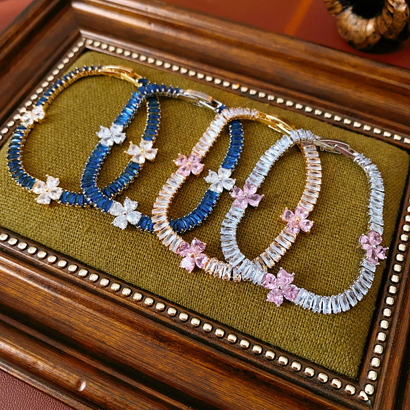 Petal Sparkle Tennis Bracelet lineup in gold and silver with pink and blue accents – baguette zircon floral design