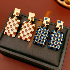 Gilded Mosaic Drop Earrings in two colors — geometric enamel checker tiles with gold-plated frame, Midnight Blue and Mocha Ivory, silver post dangle design on jewelry tray
