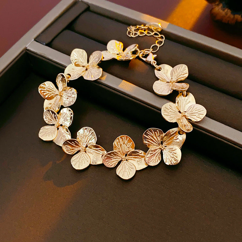 Golden Petal Elegance Set with necklace, bracelet, and earrings featuring golden floral petal details