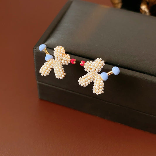 Balloon dog stud earrings crafted from imitation pearls with blue bead details — Playful Poodle Pearl Studs.