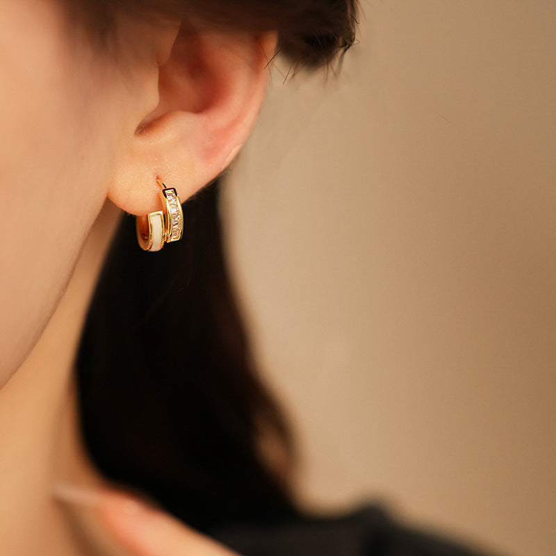Gold huggie hoop earrings with ivory enamel arc and baguette CZ row — Luna Arc Enamel Baguette Huggies.