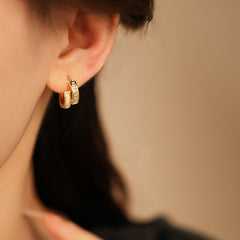 Gold huggie hoop earrings with ivory enamel arc and baguette CZ row — Luna Arc Enamel Baguette Huggies.