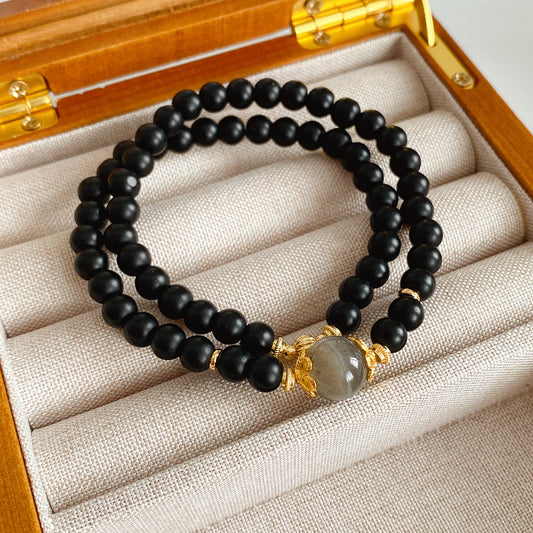 Black sandstone double-wrap bracelet with gray moonstone focal and gold accents — Midnight Moonstone Wrap Bracelet.