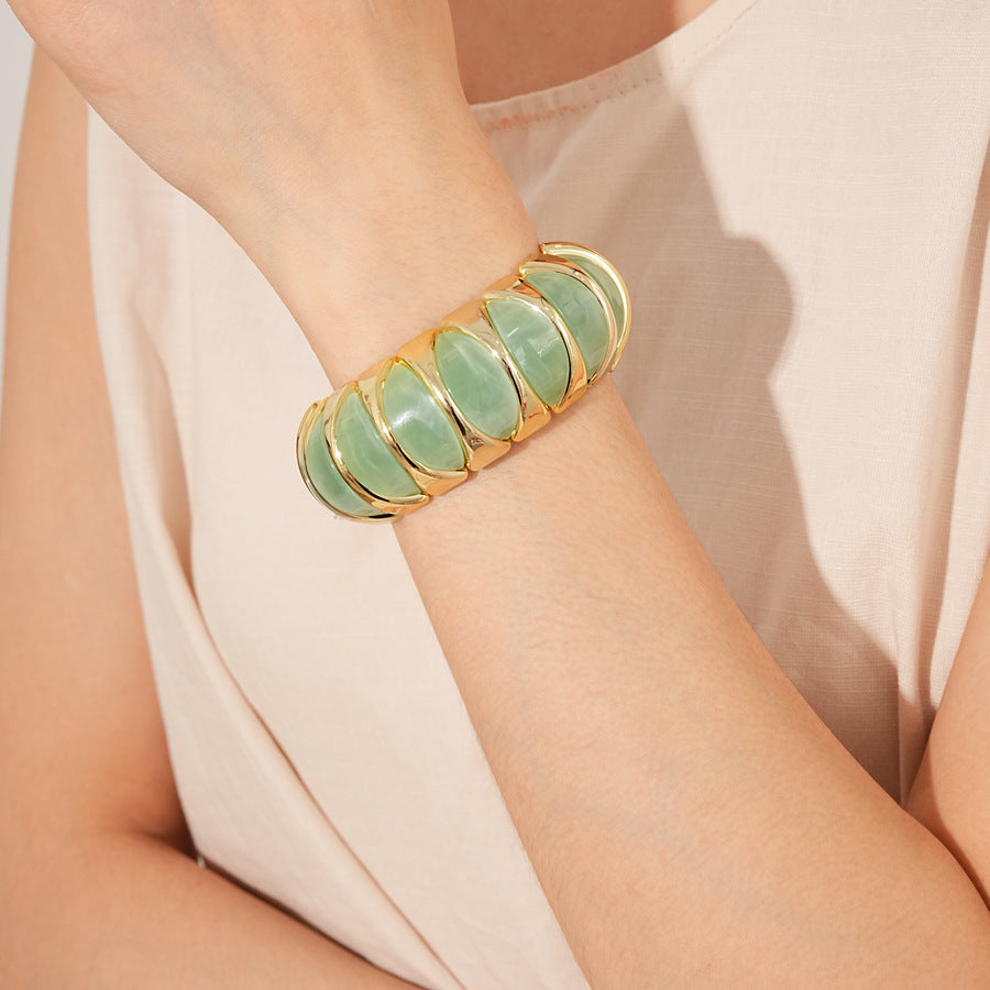 Gold-tone segmented bangle with marbled acrylic dome tiles — Gilded Capsule Resin Bangle.