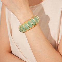 Gold-tone segmented bangle with marbled acrylic dome tiles — Gilded Capsule Resin Bangle.