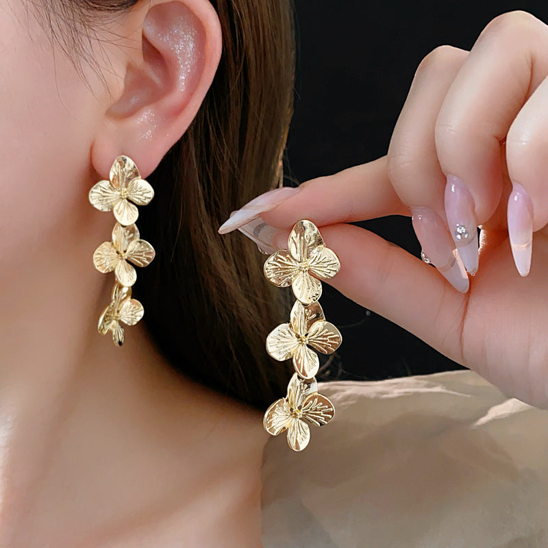 Golden Petal Elegance Set with necklace, bracelet, and earrings featuring golden floral petal details