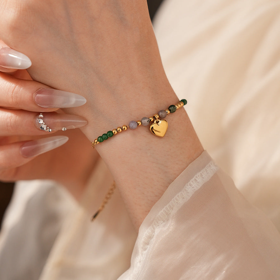 Two variant options of a malachite charm bracelet: beaded green strand with a crystal bloom charm, and a gold-tone chain with malachite accents and a heart pendant — Malachite Charm Bracelet (Variants).