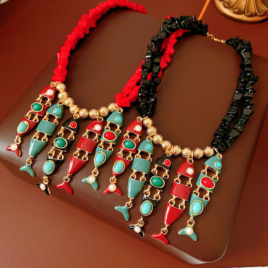 Statement necklace with articulated fishbone fringe, gold beads, and red or black chip strands — Kaleido Fishbone Fringe Necklace.