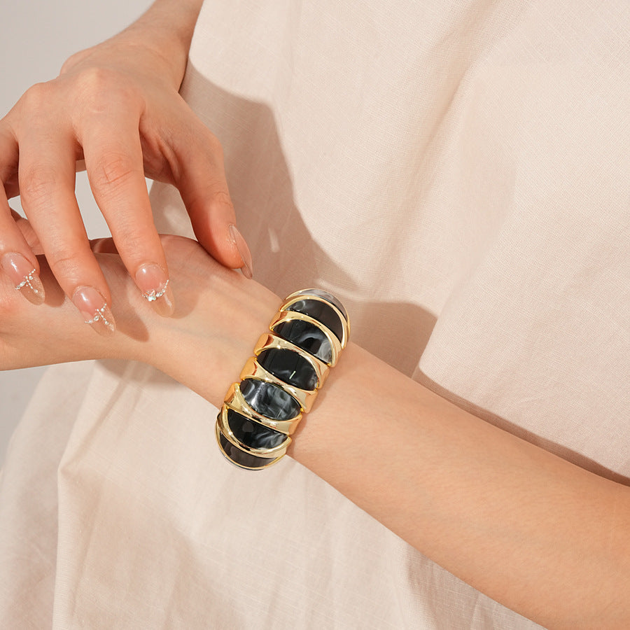 Gold-tone segmented bangle with marbled acrylic dome tiles — Gilded Capsule Resin Bangle.