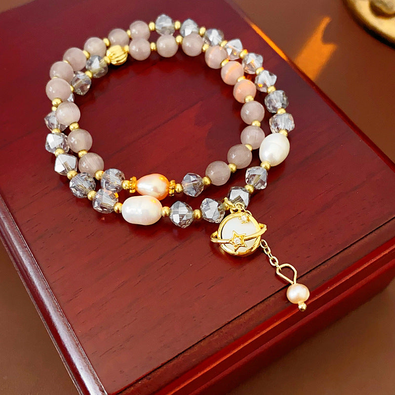 Celestial Cat’s Eye Bracelet double strand with cat’s-eye stones, freshwater pearls, crystal beads and gold planet charm