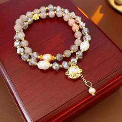 Celestial Cat’s Eye Bracelet double strand with cat’s-eye stones, freshwater pearls, crystal beads and gold planet charm