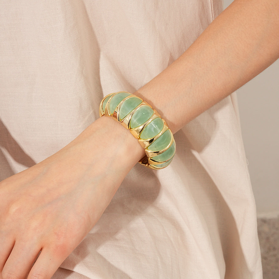 Gold-tone segmented bangle with marbled acrylic dome tiles — Gilded Capsule Resin Bangle.