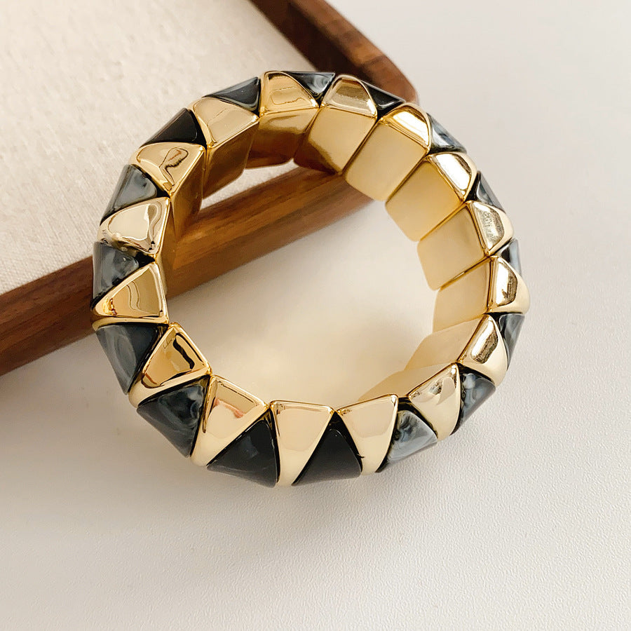 Gold-tone segmented bangle with marbled acrylic dome tiles — Gilded Capsule Resin Bangle.