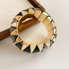 Gold-tone segmented bangle with marbled acrylic dome tiles — Gilded Capsule Resin Bangle.