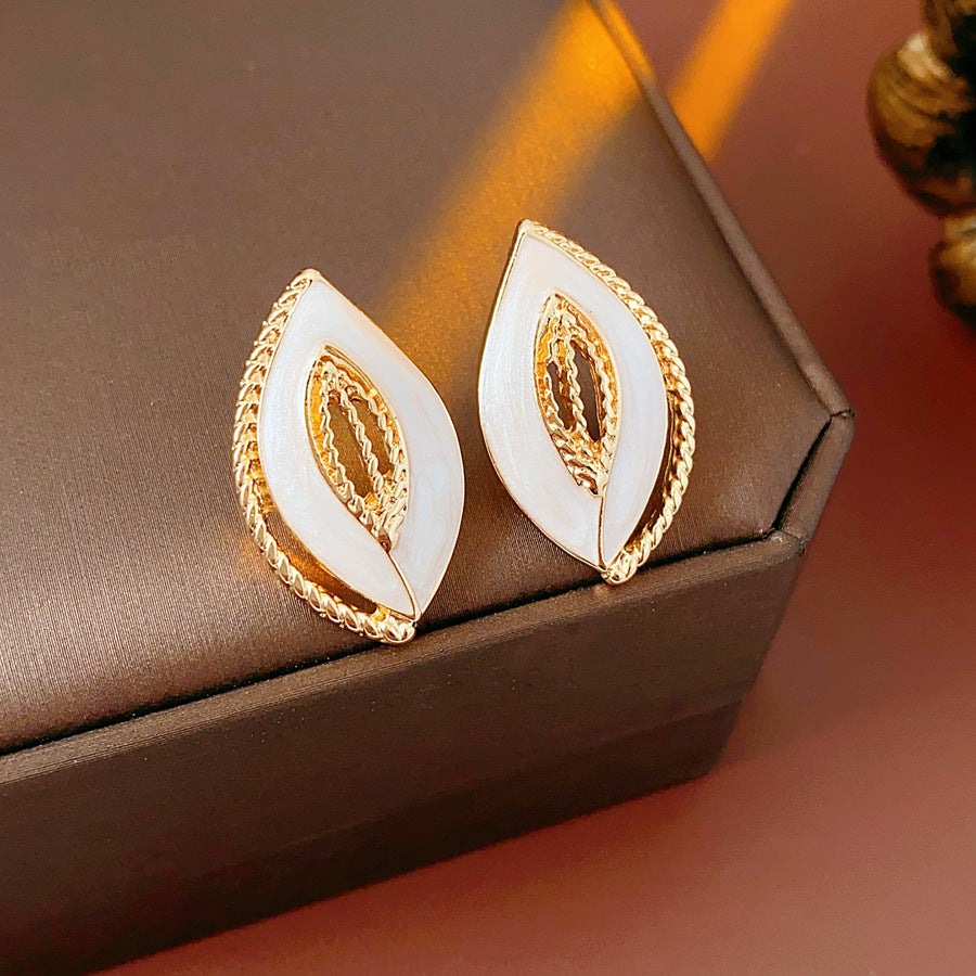 Leaf-shaped stud earrings with gold outline and white enamel – Golden Leaf Elegance Stud Earrings.