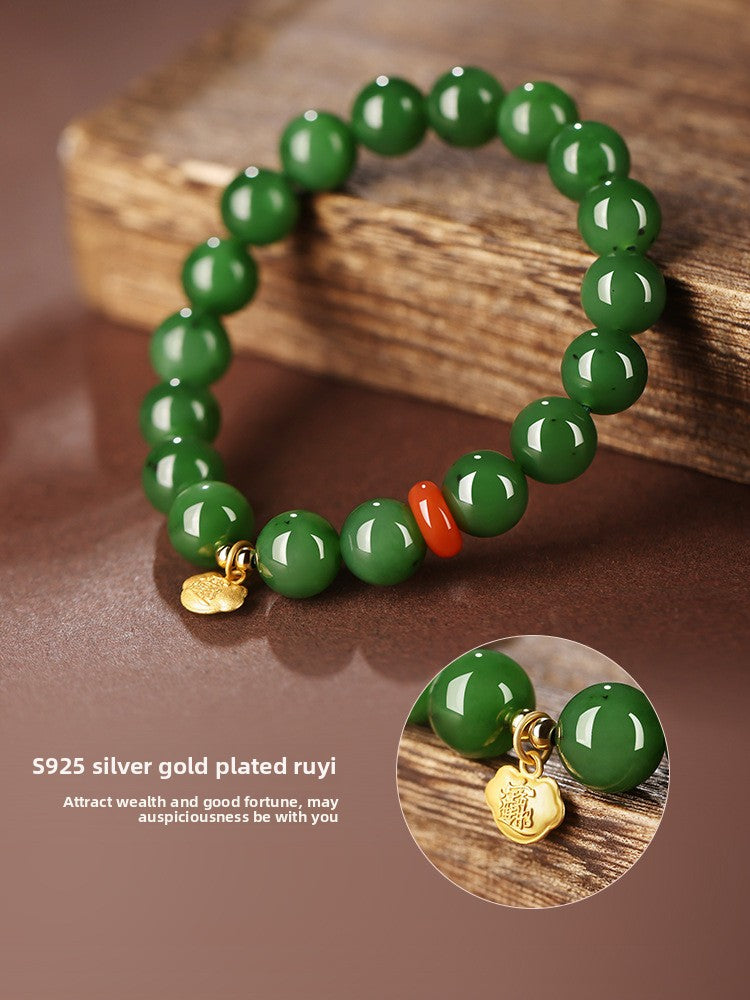 Green Hetian (nephrite) jade bead bracelet with red spacer and gold-tone charm