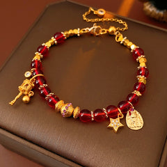 Aurora Red Prosperity Bracelet with red crystal beads and golden fortune charms—star, coin, and drum—on adjustable chain – Glazenya