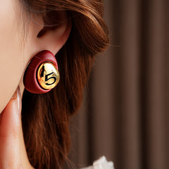 Matte pebble stud earrings with mirrored gold dome engraved with 5 — in white, black, coffee, and red — Gilded Numeral 5 Pebble Studs.
