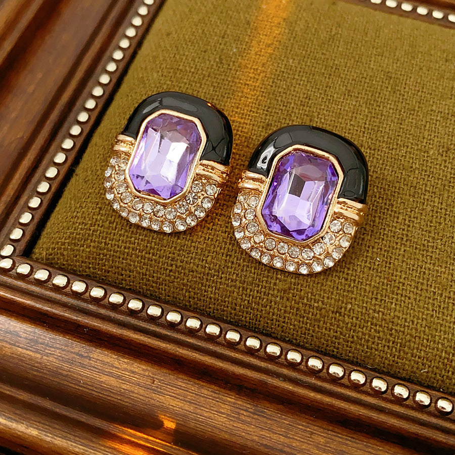 Black enamel stud earrings with amethyst-tone crystal and rhinestone frame — Midnight Amethyst Radiance Earrings.