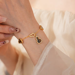 Fortune Gourd Tiger Eye Bracelet with golden gourd motifs, cubic zirconia accents, and natural tiger eye stones, displayed on red wood background
