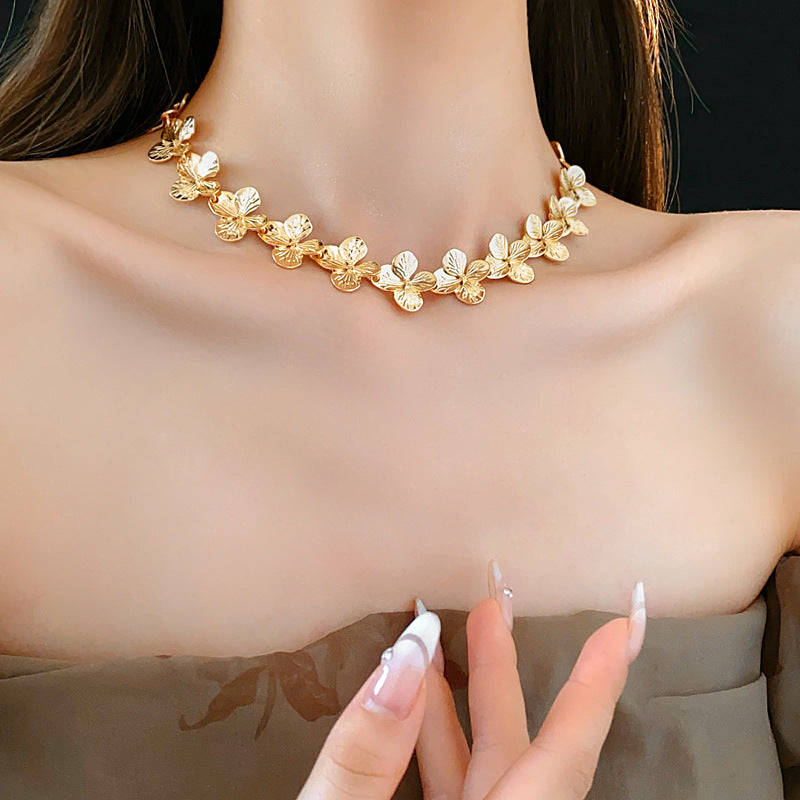 Golden Petal Elegance Set with necklace, bracelet, and earrings featuring golden floral petal details