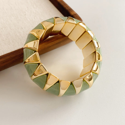 Gold-tone segmented bangle with marbled acrylic dome tiles — Gilded Capsule Resin Bangle.