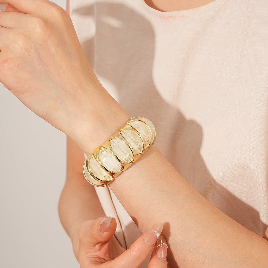 Gold-tone segmented bangle with marbled acrylic dome tiles — Gilded Capsule Resin Bangle.