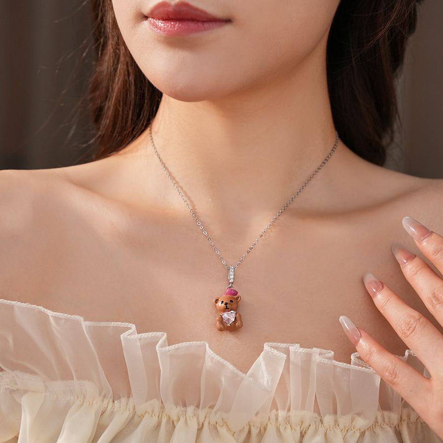 Silver-tone necklace with coffee teddy pendant and pink hat, matching teddy stud earrings with heart crystal — Sweetheart Teddy Crystal Jewelry.